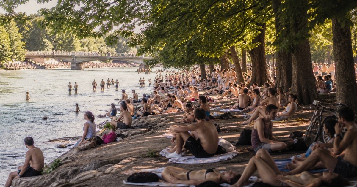 Люди у Isar в жаркий день в Мюнхене Люди у Isar в жаркий день в Мюнхене