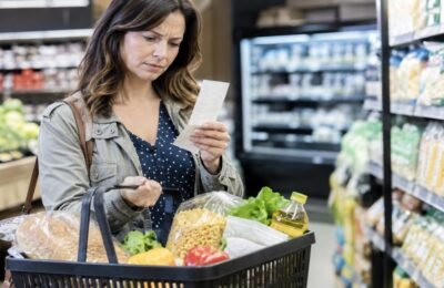 Цены на продукты: покупатель проверяет чек в супермаркете Германии