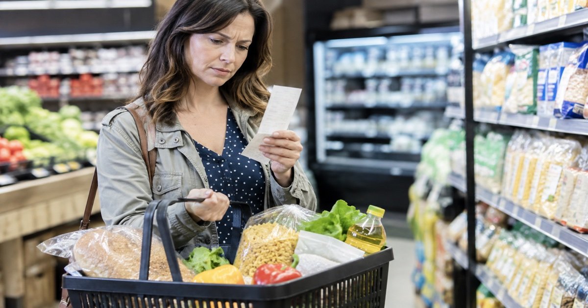 Цены на продукты: покупатель проверяет чек в супермаркете Германии Цены на продукты: покупатель проверяет чек в супермаркете Германии